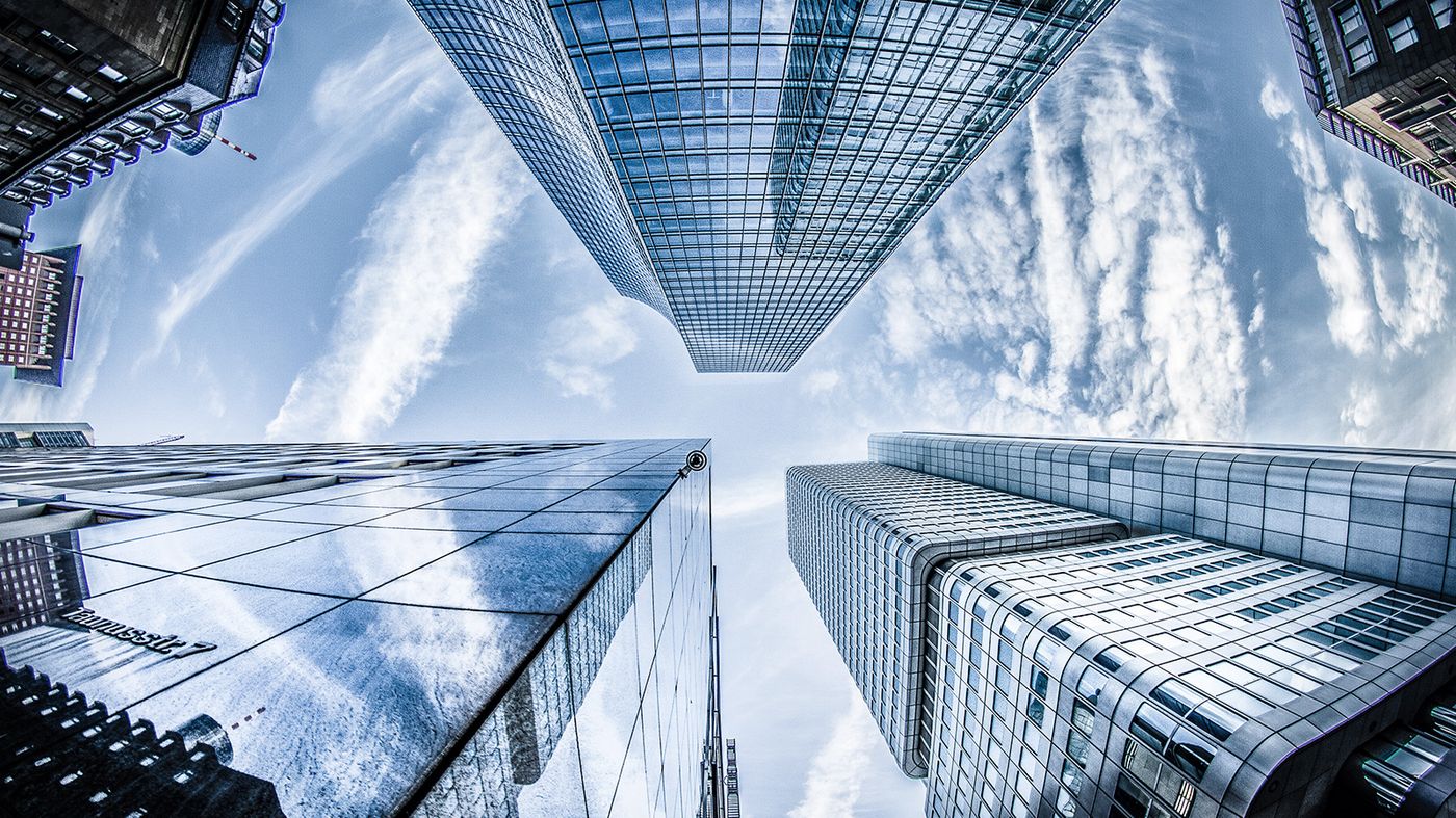 image looking up at 3 tall glass buildings