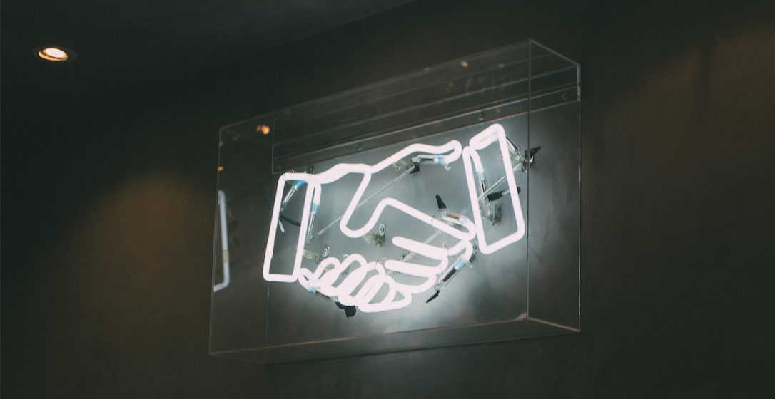 neon sign of a handshake