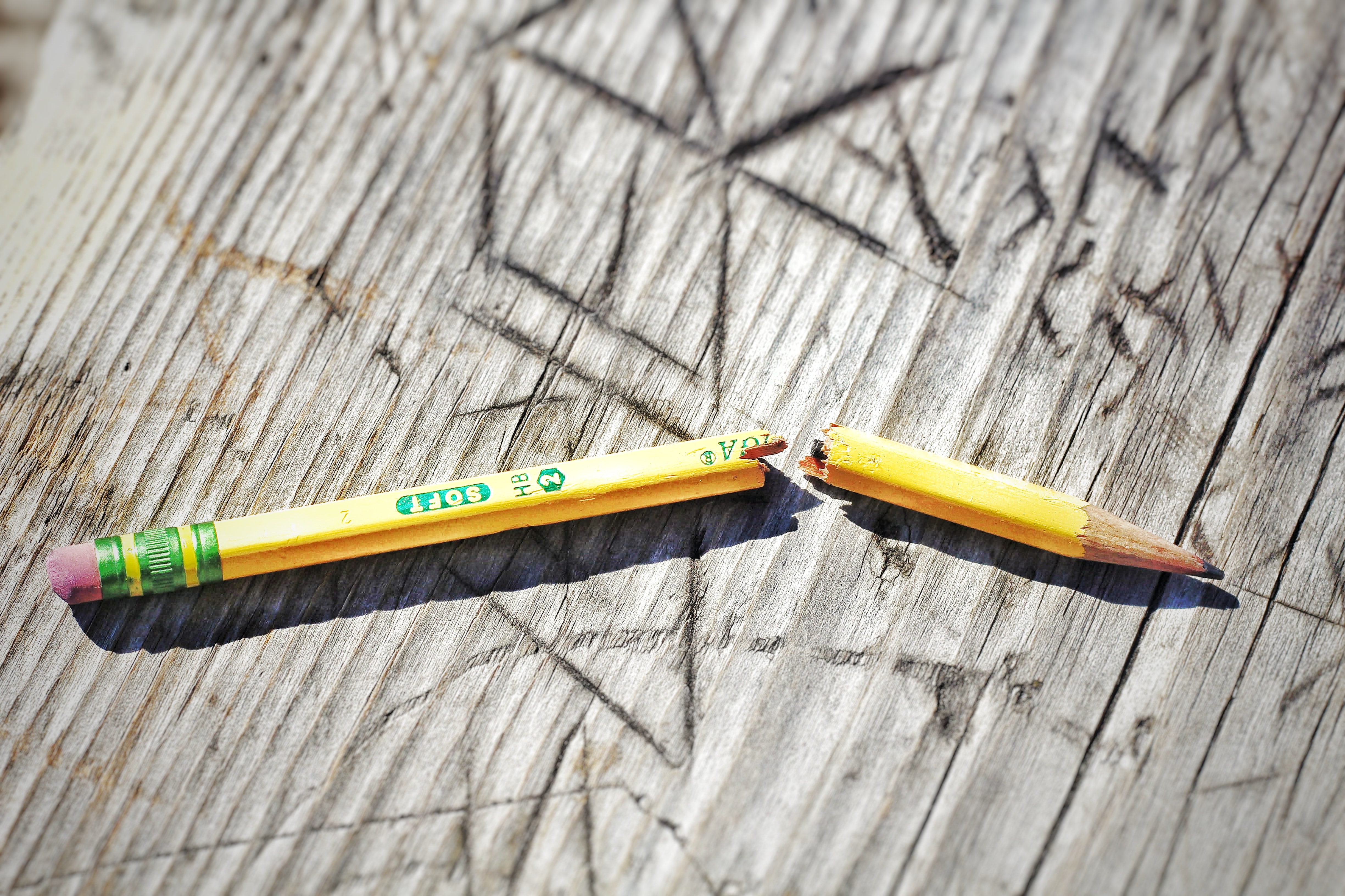 yellow broken pencil on wood background