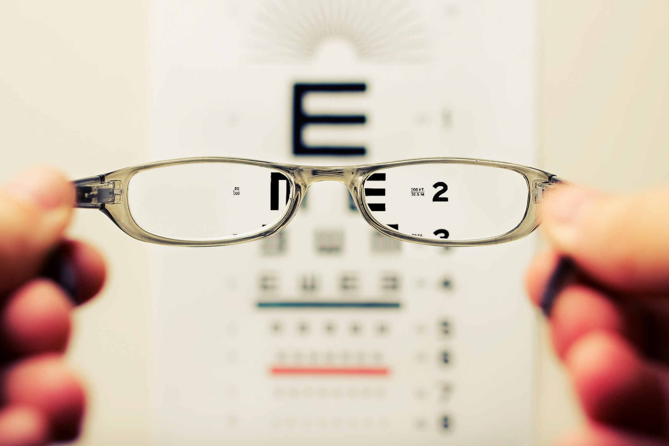glasses-lens-in-focus-of-blurred-text-background