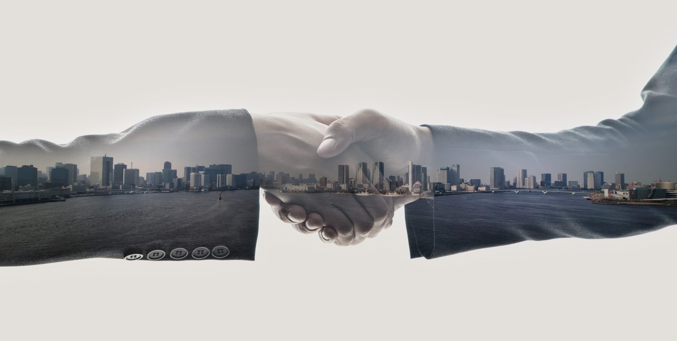 Shaking hand with city skyline overlay